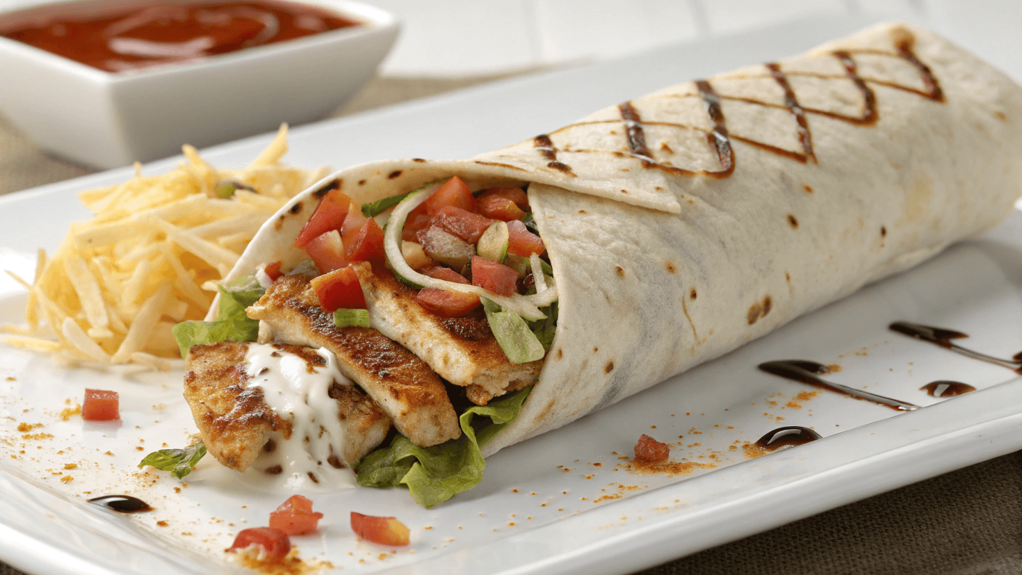 The Ultimate Guide to the Chipotle Ranch Grilled Chicken Burrito 1 Chipotle Ranch Grilled Chicken Burrito wrap served with fresh vegetables and crispy fries on a white plate