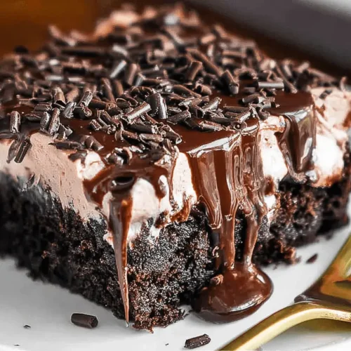 Decadent Chocolate Poke Cake: Your Ultimate Guide 2 Decadent slice of chocolate poke cake with creamy frosting, chocolate ganache, and sprinkles on a white plate.