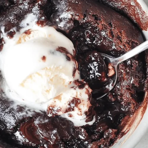 The Best Easy Chocolate Pudding Cake 2 A decadent, warm chocolate pudding cake served in a light dish, topped with melting vanilla ice cream and a spoon.