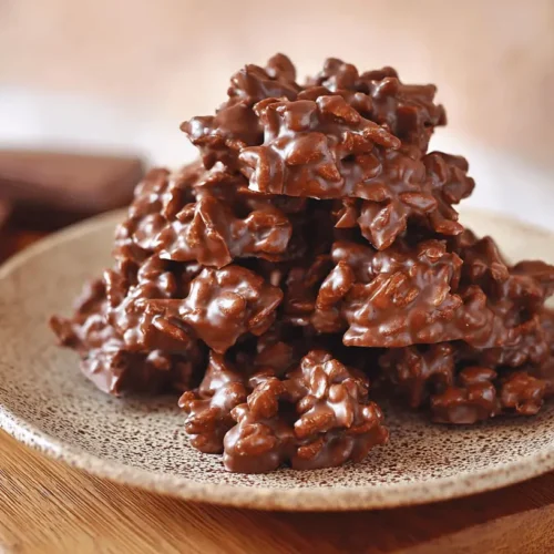 Rustic plate of homemade chocolate clusters with crunchy texture, a satisfying snack for fans of chocolate rice cakes.