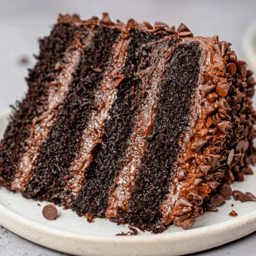Decadent Death by Chocolate Cake: The Ultimate Recipe for Chocolate Lovers 2 Close-up of a decadent, multi-layered death by chocolate cake slice, richly frosted and covered in mini chocolate chips.