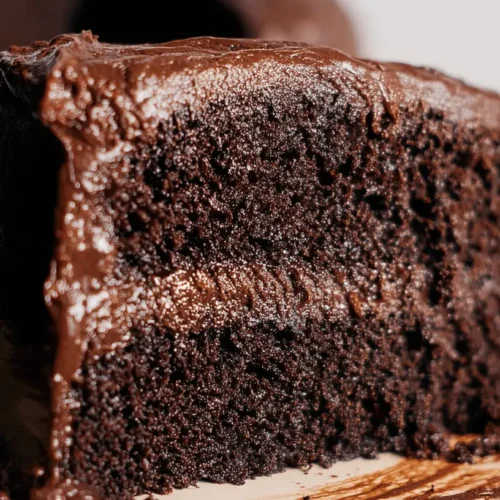 Copycat Portillo's Chocolate Cake: The Ultimate Recipe 2 Close-up of a decadent slice of Portillo's chocolate cake on a light plate, showing rich frosting and moist layers.