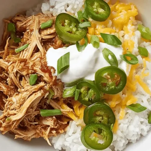 Easy Salsa Chicken Crockpot: Your New Go-To Meal Prep 2 A delicious bowl of shredded salsa chicken crockpot with rice, melted cheese, sour cream, and fresh jalapeños.