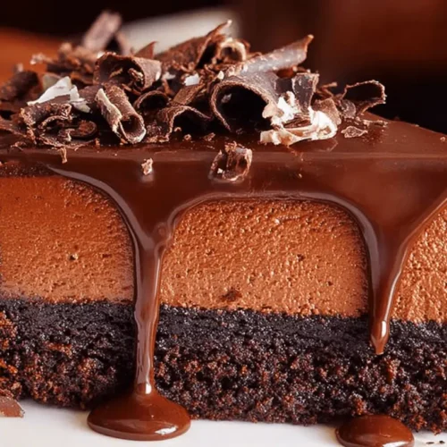 Decadent Chocolate Truffle Cake: A Rich, Three-Layer Delight 2 A decadent slice of multi-layered chocolate truffle cake with glossy ganache and chocolate curls on a white plate.