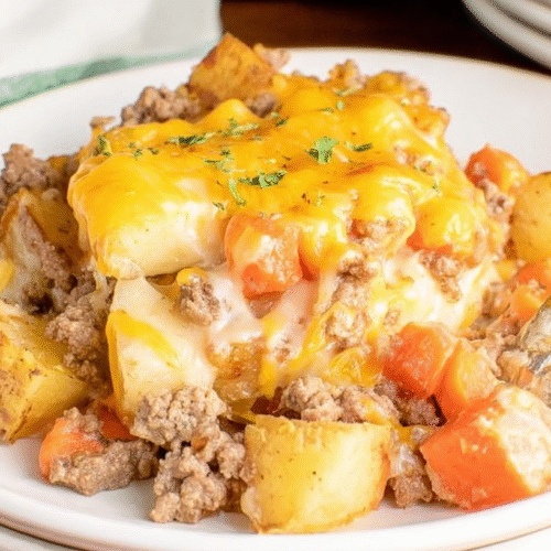 simple Hobo Casserole taken with an old camera, appetizing close-up, hearty cheesy casserole, bright white plate, silver fork plunged, crumbly ground meat, rustic potato chunks, vibrant carrots and onions, gooey golden melted cheese, sprinkled green herbs, creamy light brown sauce, stacked white plates, striped napkin, blurred warm wooden table, bright even lighting.