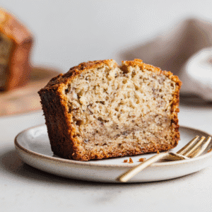 Delicious Sugar-Free Banana Bread: A Wholesome & Gluten-Free Friendly Recipe 4 Slice of moist sugar-free banana bread with banana flecks on a white plate.